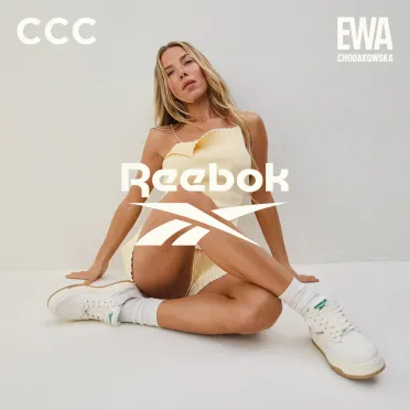 Ewa Chodakowska na beżowym tle w pozycji siedzącej 
